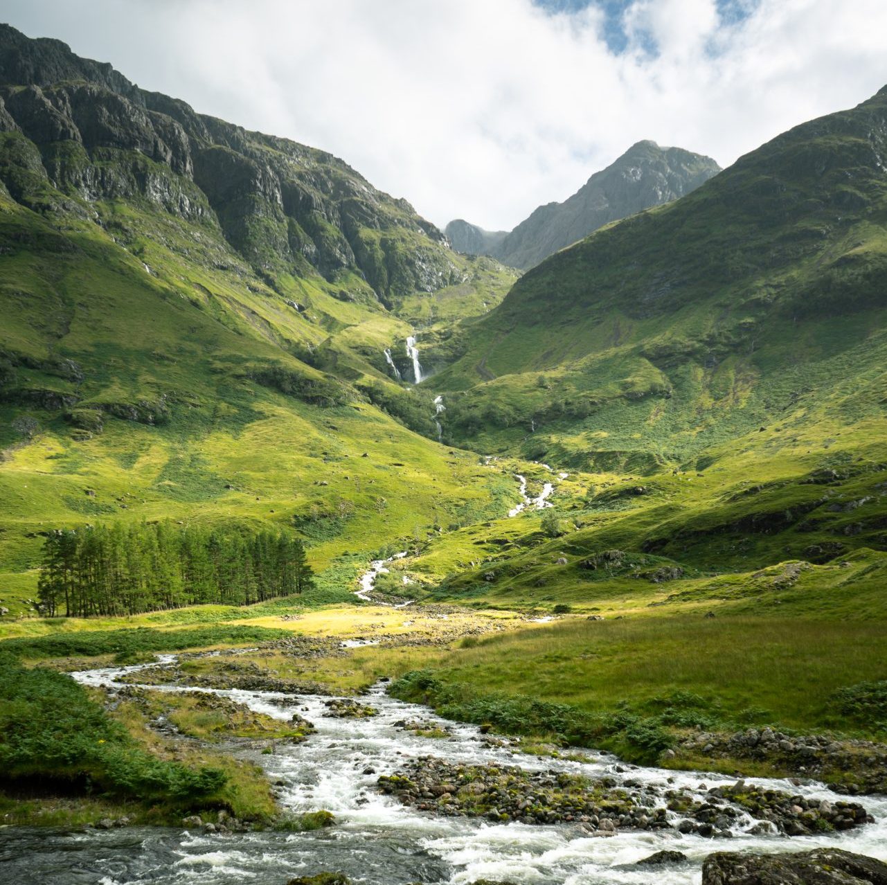 vertical shot river surrounded by mountains meadows scotland edited